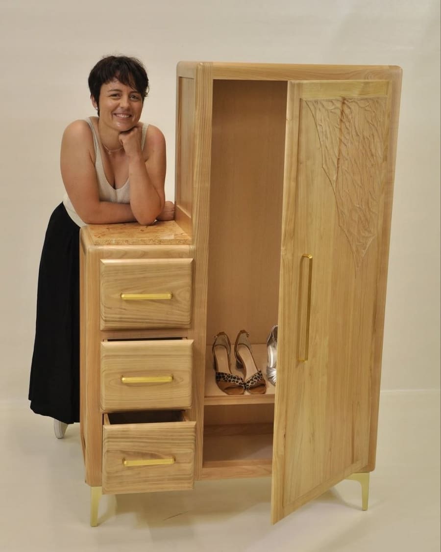 L’ébéniste aux côtés du meuble d’entrée en bois qu’elle a réalisé