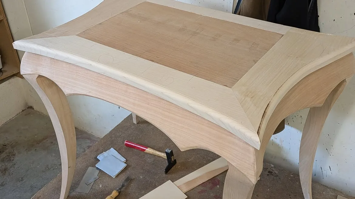 Piètement galbé du bureau cylindre en cours de fabrication dans l’atelier