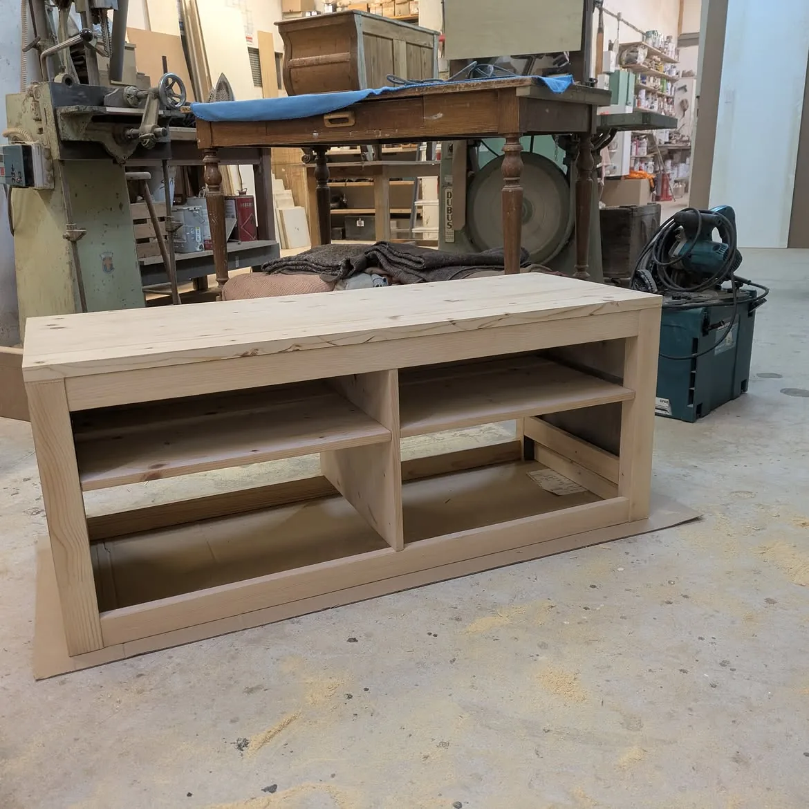 Corps du meuble TV sans ses pieds, en cours de ponçage à l’atelier