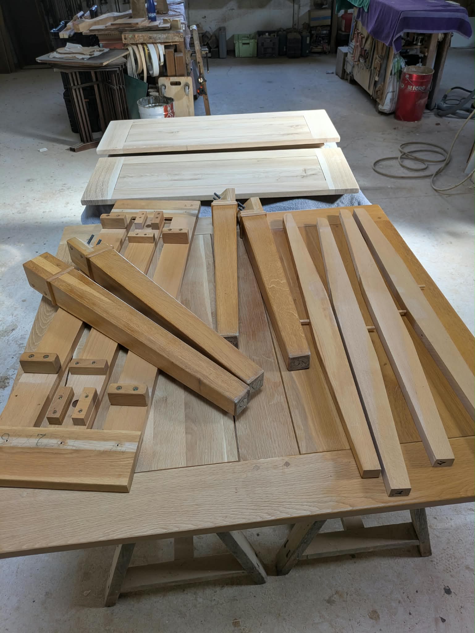 Éléments de la table en chêne disposés dans l’atelier pendant leur restauration
