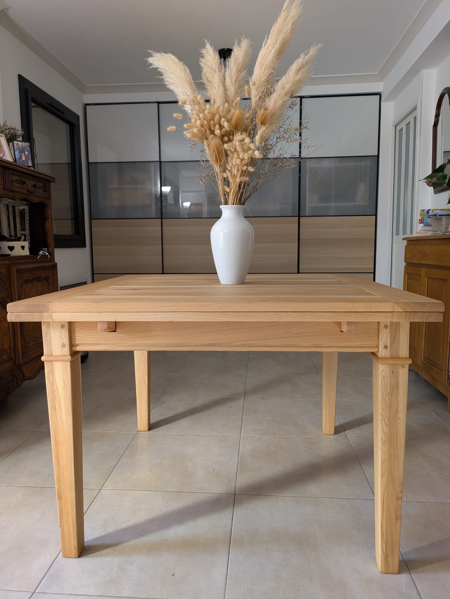 Table en chêne massif restaurée, vue de face dans le salon de la cliente